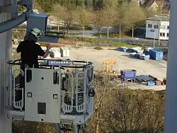 Malte Backer von der &bdquo;Stiftung Pro Artenvielfalt&ldquo; bringt einen Wanderfalken-Nistkasten hoch &uuml;ber dem Werksgel&auml;nde an. - &copy; Stiftung Pro Artenvielfalt