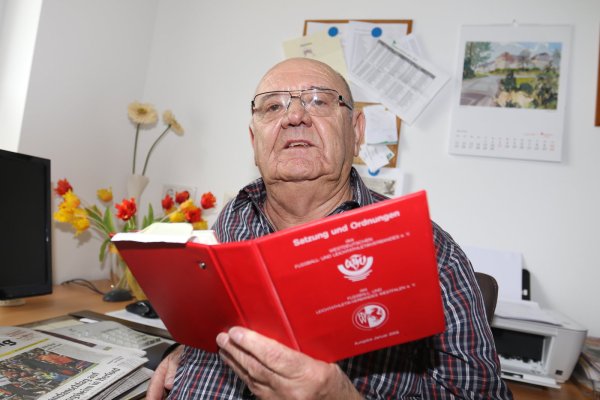 Das rote Büchlein immer zur Hand: Helmut Wallenstein mit der Satzung und den Ordnungen des Verbandes. - © Oliver König