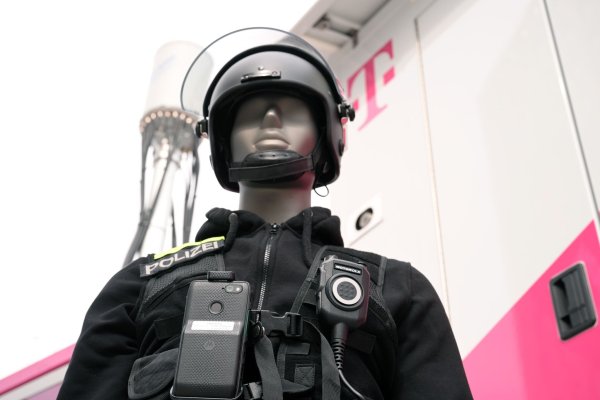 Eine Puppe in Polizei-Uniform zeigt, wie es gehen soll: An ihrer Uniform ist nicht nur ein Funkgerät, sondern auch ein Smartphone befestigt. Die Einsatzzentrale kann sich auf das Smartphone schalten und dank der Kamera sehen, was gerade los ist. - © Wolf von Dewitz/dpa