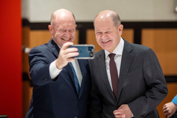 Mit einem herzhaften Lachen: Olaf Scholz (r) und Chris Coons machen ein Selfie. - © -/Bundesregierung/dpa