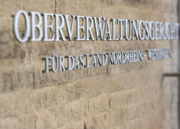 Auf einem Schild steht der Schriftzug: «Oberverwaltungsgericht für das Land Nordrhein-Westfalen». - © Guido Kirchner/dpa/Symbolbild