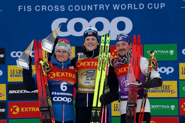 Johannes Hoesflot Klaebo (M) aus Norwegen jubelt neben dem Zweitplatzierten Mika Vermeulen (l) aus Österreich und dem Drittplatzierten Hugo Lapalus aus Frankreich auf dem Podium der Tour de Ski. - © Alessandro Trovati/AP/dpa