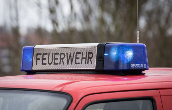 Auf einer Straße in Dülmen sichern Feuerwehrleute einen Einsatzort - und werden von einem Autofahrer in Gefahr gebracht. (Symbolbild) - © Friso Gentsch/dpa