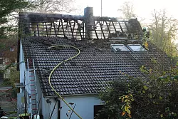 Dicker Qualm zieht aus den Dach eines Einfamilienhauses in der Stra&szlig;e "An der Hellr&uuml;sche" in Bad Salzuflen. Eine Familie samt Hunden konnte sich gl&uuml;cklicherweise selbst in Sicherheit bringen. - &copy; Feuerwehr Bad Salzuflen