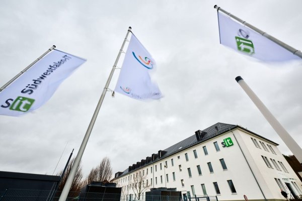 Fahnen wehen vor dem Gebäude von Südwestfalen-IT im Wind. - © Bernd Thissen/dpa