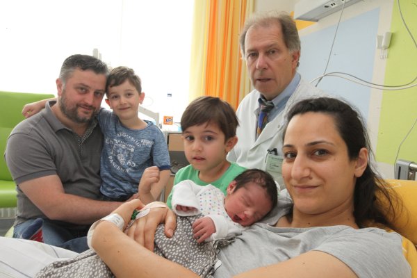 Gesundes Baby: Ein zufriedener, gesunder kleiner Kerl ruht im Arm von Mama Yeliz Kayikci. Chefarzt Dr. Andreas Luttkus hat es auf die Welt geholt. Papa Fuat, der sechsjährige Enes und der dreijährige Emre freuen sich. - © Vera Gerstendorf-Welle