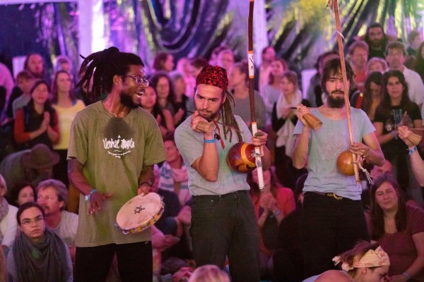 Mit Rhythmusgefühl: Capoeira-Workshop-Leiter Bobby Gomes (links) gibt den Takt vor und fordert die Besucher im Hauptzelt auf dem Yoga-Vidya-Gelände zum spontanen Mitmachen auf. - © Torben Gocke