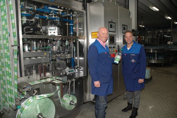 Strahlen Zuversicht aus: Volker Schlingmann (links) und Stefan Brüggemann stehen in der großen Produktionshalle an der B 239 in Bad Meinberg vor einer Maschine, in der gerade Forstetal-600-Flaschen etikettiert werden. - © Manfred Brinkmeier