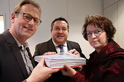 Iris Beverung und Pfarrer Dieter B&ouml;kemeier &uuml;berreichen Landrat Dr. Axel Lehmann (Mitte) die Unterschriftenlisten. - &copy; Vera Gerstendorf-Welle