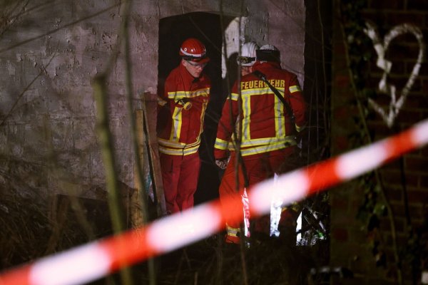 Rettungskräfte beraten vor eine Gebäude, in dem sich Personen in einem Tunnel verschanzt haben. - © David Young/dpa