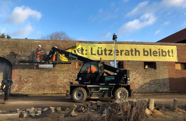 Arbeiter entfernen ein Banner «Lützerath bleibt!» von einer Wand. - © Petra Albers/dpa