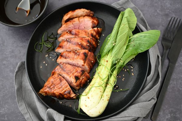 Hoisin-Sauce gibt dem Schweinefilet Würze und eine Karamellnote. Dazu wird Pak Choi serviert. - © Julia Uehren/loeffelgenuss.de/dpa-tmn