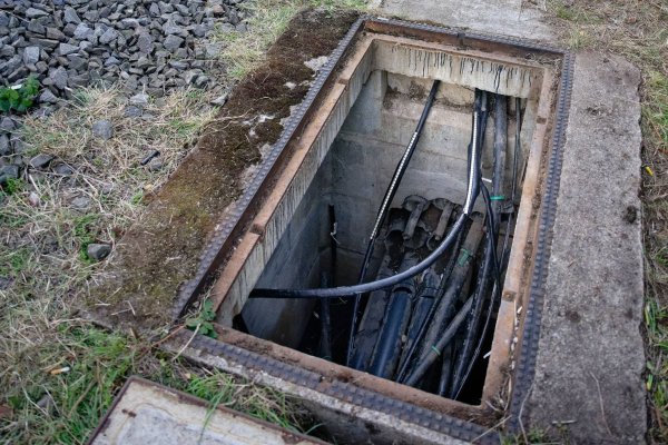 Durchtrennte Kabel sind am Rand der Bahnstrecke Köln-Düsseldorf in einem Wartungsschacht zu sehen - © Henning Kaiser/dpa