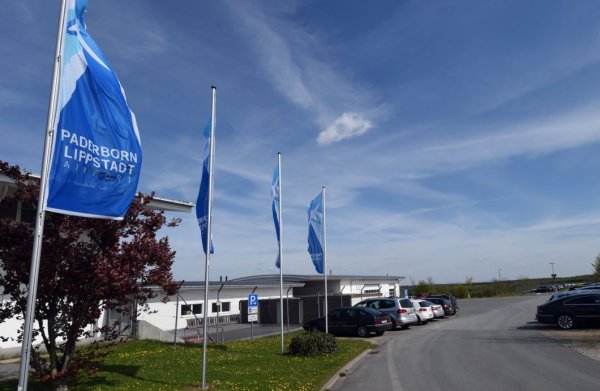 Weitere Bebauung Richtung Paderborn geplant: Während am Airport-Forum (l.) die Flagge im Wind steht, reifen auf den Grünflächen hinter der Frachtgut-Abfertigung (r.) Gedankenspiele für ein Luftfahrtmuseum am heimischen Flughafen. - © Marc Köppelmann