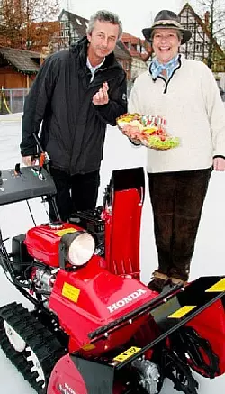 Kleine Stärkung: Wolfgang Jäger hat die nagelneue Schneefräse mit Raupenantrieb aufs Eis gefahren. Marion Schlüter reicht ihm fürs Foto ein paar Südtiroler Leckereien. Foto: Backe