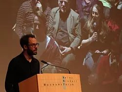 Daniel Domscheit-Berg war per Video in dreifacher Ausf&uuml;hrung an den W&auml;nden des Vortragsraumes zu sehen, sp&auml;ter wie hier auch das Fragen stellende Publikum. Wegen des Andrangs stand eine Videoleinwand im Foyer des HNF - &copy; FOTO: KRISTINE GRESSH&Ouml;NER