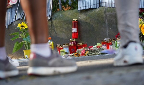 Zwei Menschen stehen vor einem Zaun, an dem mit Kerzen und Blumen eines Jugendlichen gedacht wird. - © Gregor Bauernfeind/dpa/Archivbild