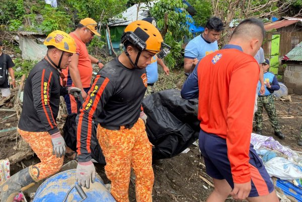 Rettungskräfte bergen eine Leiche nach einem Erdrutsch, der durch den Tropensturm Trami ausgelöst wurde - © Jim Gomez/AP/dpa