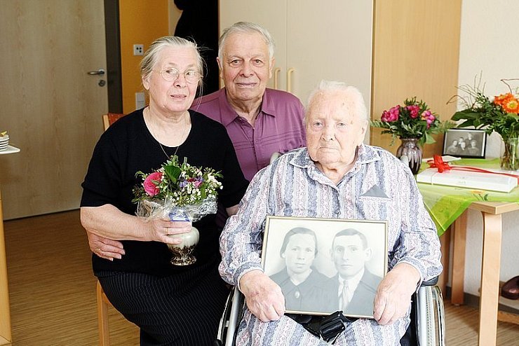 Gratulation: Maria Wall-Martens und Willi Martens freuen sich mit Katharina Wall (von links) über die 105 Lebensjahre der ältesten Lagenserin. In den Händen hält sie ein Foto von ihr und ihrem verstorbenen Mann Heinrich. - © Foto: Bockwinkel