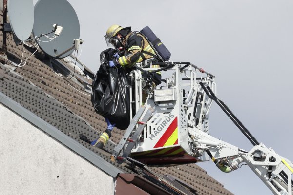 Ein Feuerwehrmann birgt die letzte Vermisste in einem Leichensack aus einem Haus in Solingen. - © David Young/dpa