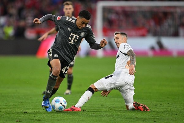 Bayern-Profi Jamal Musiala (links) dribbelt an Leverkusens Alejandro Grimaldo vorbei. - © Sven Hoppe/dpa
