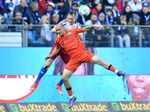 Paderborns Sven Michel (vorn) und Hamburgs Sebastian Schonlau kämpfen um den Ball. - © Daniel Bockwoldt/dpa