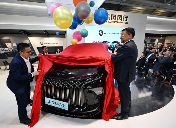 Manager der Dongfeng Liuzhou Motor Co. Ltd. enthüllen auf der IAA ein neues Fahrzeug der Marke Forthing. - © Martin Schutt/dpa