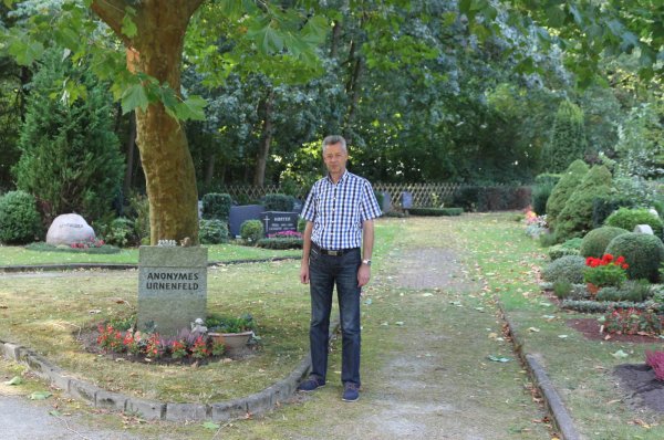 Klaus Sunkovsky steht unter der großen Kirsche, die das anonyme Urnenfeld beschattet. - © Thomas Dohna