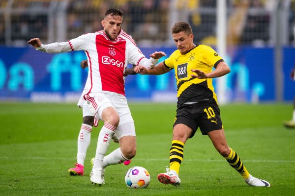 Dortmunds Thorgan Hazard (r) und Amsterdams Branco van den Boomen kämpfen um den Ball. - © Marius Becker/dpa/Archivbild
