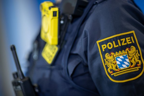 Eine Polizistin trägt ein Abzeichen der bayerischen Polizei. - © Daniel Karmann/dpa/Symbolbild