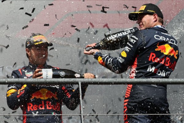 Der zweitplatzierte Sergio Perez (l) und der Sieger Max Verstappen feiern gemeinsam auf dem Podium. - © Benoit Doppagne/Belga/dpa