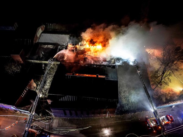 Die Feuerwehr setzte Drehleitern und ein Feuerlöschboot ein, um den Großbrand zu bekämpfen. - © Justin Brosch/dpa