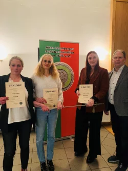 Kerstin Klasen, Sabine Gange und Jasmin Whiting (von links) schreiben Geschichte. Sie sind verantwortlich für das erste Frauenrot im Alten Blomberger Schützenbataillon. Oberst Peter Begemann (rechts) gratuliert. - © ABS