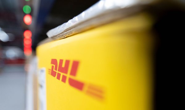 Ein Paket von DHL in einem Logistikzentrum - wertvolle Pakete in die USA werden vorerst nicht mehr angenommen. - © Hendrik Schmidt/dpa