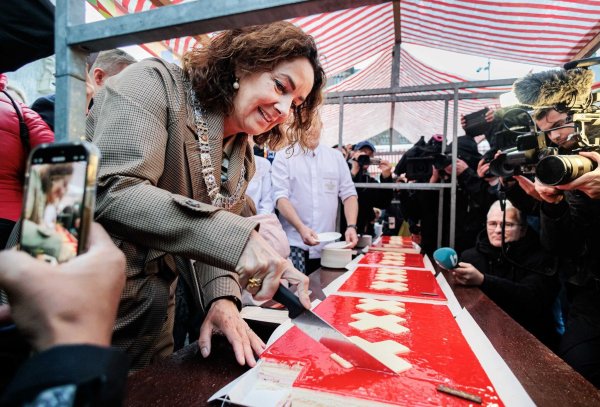 Amsterdams Bürgermeisterin Femke Halsema schneidet die lange Torte an. - © Ramon Van Flymen/ANP/dpa