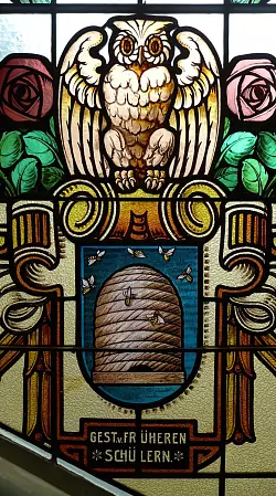 Hochwertige Arbeit: Die Glasmalerei Müller aus Quedlinburg hat die Fenster im Leopoldinum 1907 gestaltet. Dies hier zeigt die Eule als Sinnbild der Weisheit, die auf Fleiß, dargestellt durch die Bienen, gründet. - © Heinemann