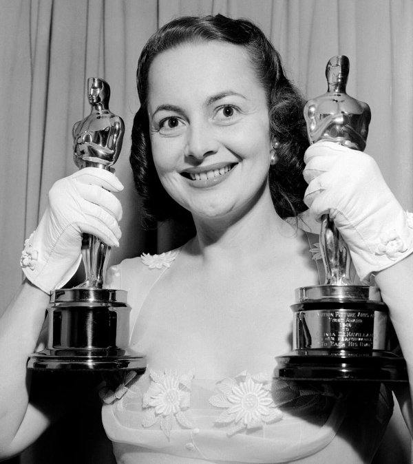 Schauspielerin Olivia de Havilland hält zwei Oscars nach der Verleihung. - © Uncredited/AP/dpa