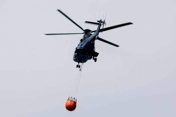 Ein Löschhubschrauber der Bundespolizei fliegt über dem Zeithainer Tagebau und nimmt Wasser auf, um den Waldbrand Gohrischheide zu bekämpfen. - © Daniel Wagner/dpa