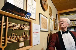 Seit vielen Jahrzehnten kennen die S&auml;nger Harald Fischer in seinem weinroten Chorleiter-Jackett - hier in seinem heimischen Musikzimmer. - &copy; Foto: Blum