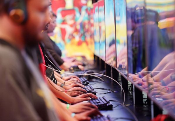 Messebesucher testen Computerspiele auf der der Gamescom in Köln (2022). - © Oliver Berg/dpa