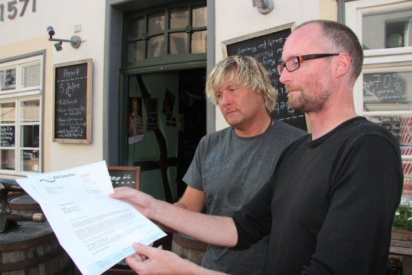 Zerknirscht: Uwe Ortmann (rechts) und sein Bruder Jürgen Ortmann betrachten den Bußgeldbescheid der Stadtverwaltung. 228 Euro sollen sie zahlen, da es vor der Tür ihrer Kneipe in der Osterstraße zu laut geworden war. - © Stefan Backe