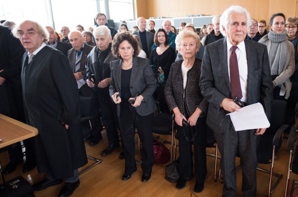 Die Zeugen der Nebenklage, William Glied (r-l), Irene Weiss, deren Tochter, Max Eisen und Mordechai Eldar sowie ihr Anwalt Thomas Walther (l) stehen am 19.02.2016 in Detmold (Nordrhein-Westfalen) beim Einzug des Gerichts an ihren Plätzen. Dem 94-Jährigen ehemaligen SS-Wachmann Hanning wird Beihilfe zum Mord in mindestens 170000 Fällen vorgeworfen. Der Prozess vor dem Landgericht Detmold findet in den Räumen der Industrie und Handelskammer statt. - © dpa