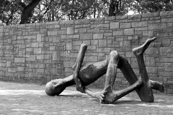 „Der sterbende Häftling": Die überlebensgroße Skulptur der französischen Bildhauerin und Holocaust-Überlebenden Françoise Salmon (geb. 1920) in der KZ-Gedenkstätte Neuengamme zeigt einen bis auf das Skelett abgemagerten Häftling. - © Wikipedia