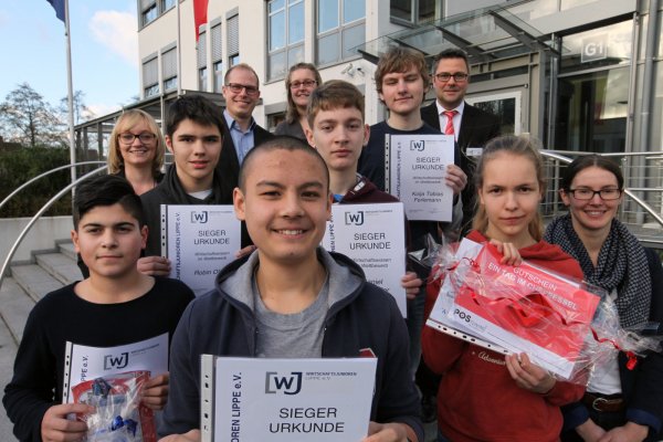 Fit in Sachen Wirtschaft: vorneweg der Kreissieger Mika Behrens. Dahinter die nächstplatzierten (von links) Robin Bulut, Robin Oliver, Daniel Schneider, Kolja Tobias Ferlemann und Mira Fricke-Begemann. Im Hintergrund die Wirtschaftjunioren Svenja Jochens, Kay Grotebrune und Ronja Krencky sowie als Gastgeber von der Ecclesia-Versicherung Stefan Wölfle und Iris Gillmann. - © Bernhard Preuß