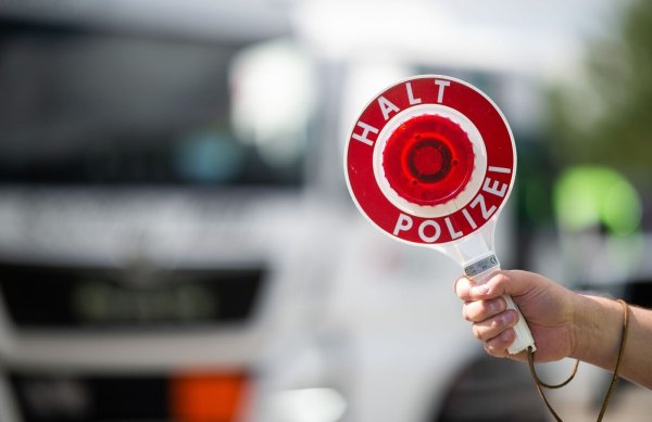 Ein Polizist hält bei einer Verkehrskontrolle eine Polizeikelle in der Hand. - © Jonas Güttler/dpa/Symbolbild