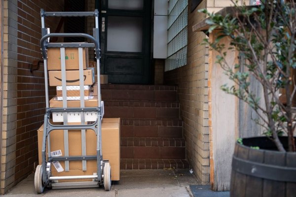 Gestapelte Pakete in einem Hauseingang. Das Postgesetz ist in seinen wesentlichen Teilen schon seit 1998 gültig. - © Sebastian Gollnow/dpa