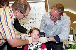 Ein kurzer Augenblick, dann ists geschafft: Bernd Pastern (links) und Joachim Krome greifen zeitgleich zur "Pistole", um Hannah die Ohrl&ouml;cher zu schie&szlig;en. "Ein bisschen wehgetan hats schon", gesteht die F&uuml;nfj&auml;hrige sp&auml;ter. - &copy; Foto: Buhrmester