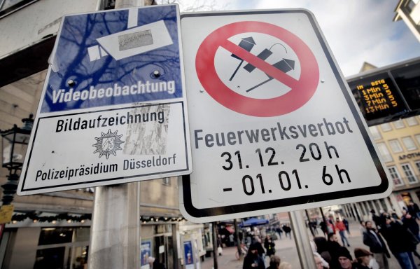 Hinweisschilder auf Videoüberwachung und Böllerverbot hängen am Zugang zur Altstadt in Düsseldorf. - © Martin Gerten/dpa