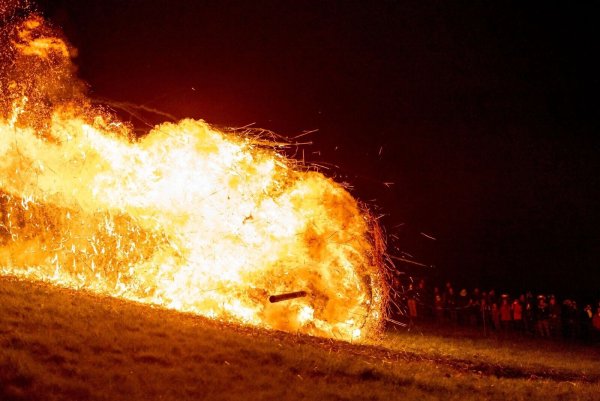 Ein brennendes Holzrad rollt den Osterberg hinunter in Richtung der Ortschaft Lügde beim jährlichen Osterräderlauf. - © Christoph Reichwein/dpa