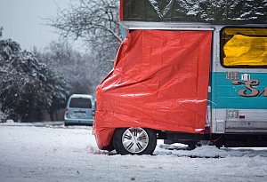 Eine Plane schützt die Fahrerkabine eines Wohnmobils - Frank Rumpenhorst/dpa/dpa-tmn